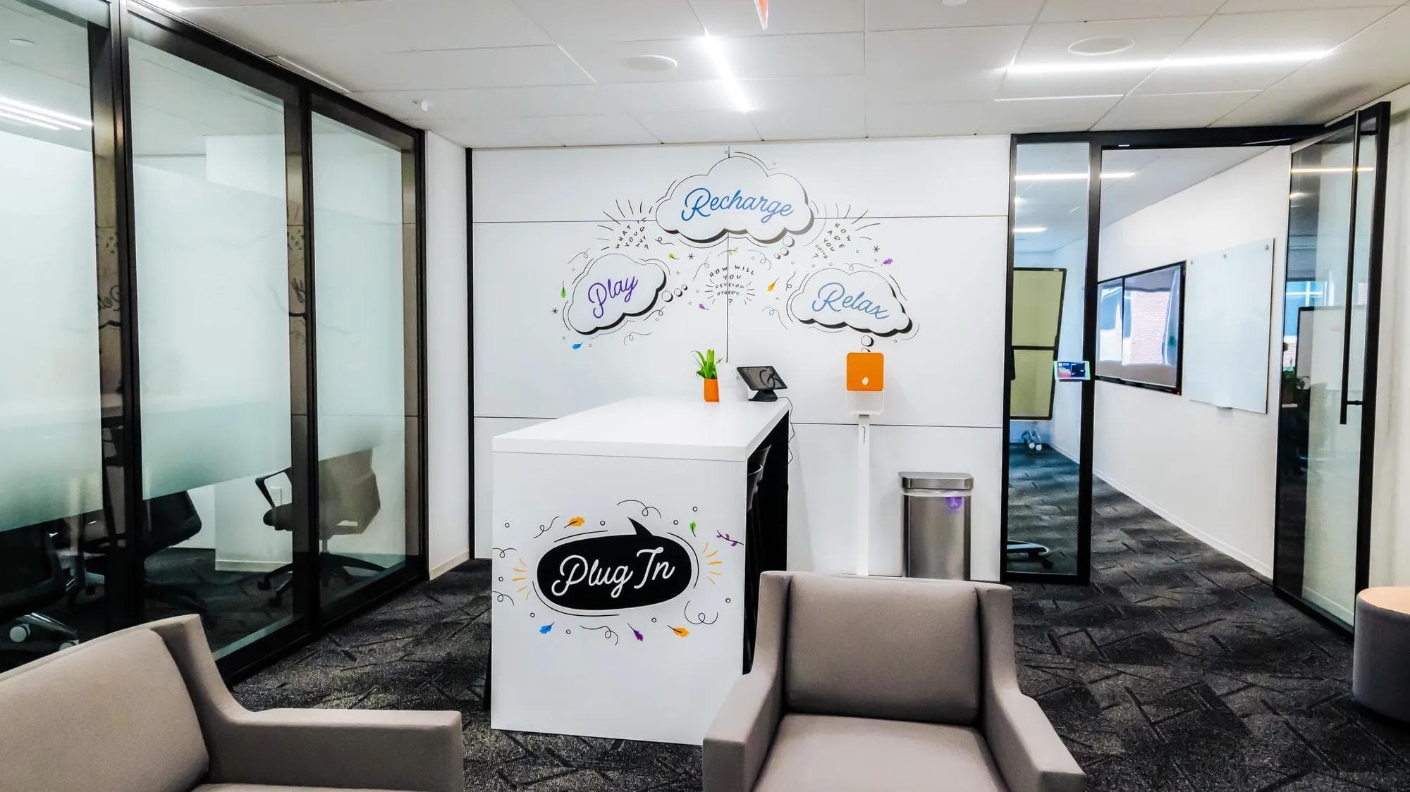 ATD charging station in our learning center, with a white table that has artwork on it and above it surrounded by chairs and open space.